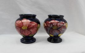 A pair of Moorcroft pottery vases, decorated in the Clematis pattern to a blue ground,