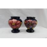 A pair of Moorcroft pottery vases, decorated in the Clematis pattern to a blue ground,