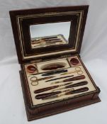 An early 20th century leather travelling manicure set, enclosing a mirror and scissors, nail pad,