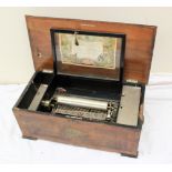 A walnut table top music box, the top transfer decorated with a coat of arms,