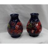 A pair of Moorcroft pottery baluster vases decorated in the Anemone pattern to a blue ground,