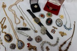 A collection of costume jewellery including a wristwatch, faux pearls, brooches,