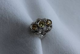 A diamond dress ring, set with three fancy yellow round brilliant cut diamonds,