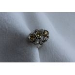 A diamond dress ring, set with three fancy yellow round brilliant cut diamonds,