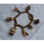9ct yellow gold charm bracelet, set with numerous charms including a matador, toby jug, lanterns,
