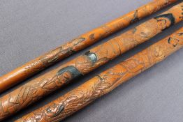 An ebony dogs head walking stick together with three carved bamboo walking sticks