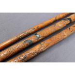 An ebony dogs head walking stick together with three carved bamboo walking sticks