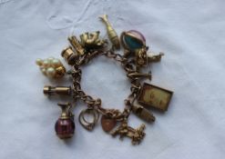 A 9ct yellow gold charm bracelet set with numerous charms including figures on a bench, speed boat,