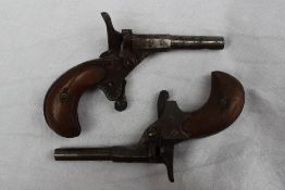 Two 19th century 'Bicycle' Muff pistols, with wooden grips,