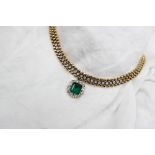 An 18ct yellow gold necklace set with an emerald and diamond pendant,