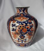 A Japanese Imari porcelain vase of baluster shape, decorated with a vase of flowers in iron reds,