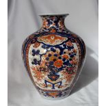 A Japanese Imari porcelain vase of baluster shape, decorated with a vase of flowers in iron reds,