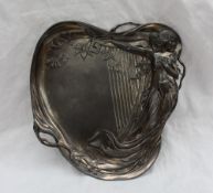 An electroplated WMF dish of heart shape, cast with a maiden in diaphanous dress leaning on a harp,