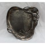 An electroplated WMF dish of heart shape, cast with a maiden in diaphanous dress leaning on a harp,