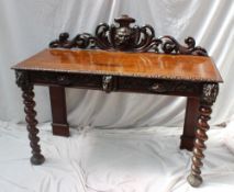 A 19th century carved oak low countries side table the raised back carved with a head and scrolls,