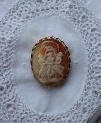 A shell cameo brooch, depicting the three graces, to a yellow metal setting,