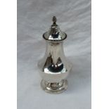 A George V silver sugar caster with a flame finial and a pierced top above a baluster body and a
