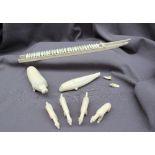 Inuit carved walrus tusk models, including a model husky sled, walrus,