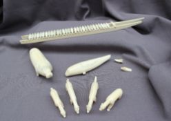Inuit carved walrus tusk models, including a model husky sled, walrus,