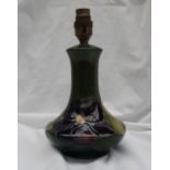 A Moorcroft pottery table lamp decorated in the clematis pattern, to a green ground,