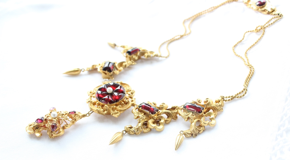 A yellow metal and red stone necklace with scrolling leaf design with pear shaped drops - Bild 2 aus 4