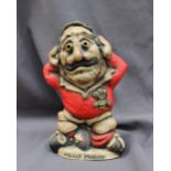 A John Hughes pottery Grogg titled "Mauler Morgan", in a Welsh jersey with his arms behind his head,