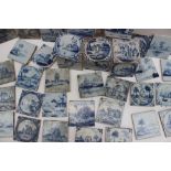 A collection of blue and white delft tiles, depicting cottages,