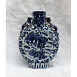 A Chinese porcelain moon flask, decorated with dogs of foo amongst clouds, with dragon handles,