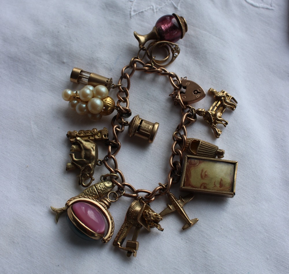 A 9ct yellow gold charm bracelet set with numerous charms including figures on a bench, speed boat, - Bild 2 aus 3