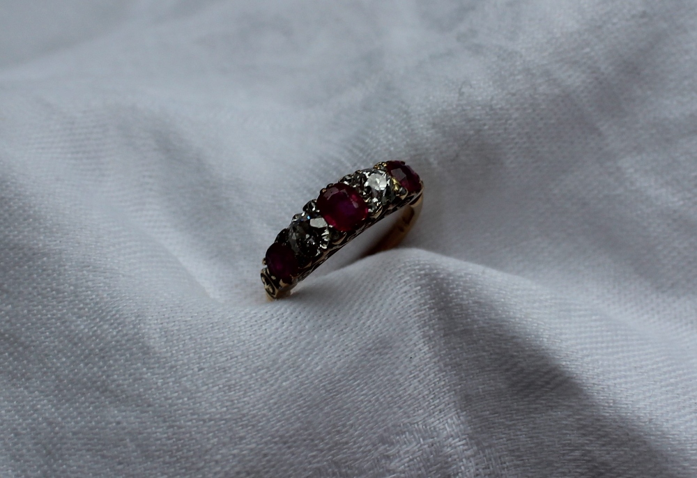 A ruby and diamond line ring, set with three rubies and two round old cut diamonds,