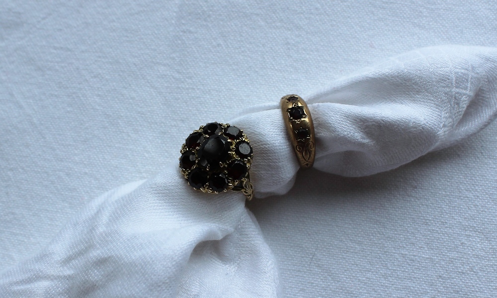 A 9ct yellow gold garnet set dress ring, set with a central oval garnet,