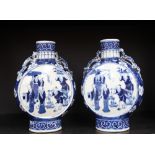 A pair of Chinese blue and white porcelain moon flasks, decorated with figures, with dragon handles,