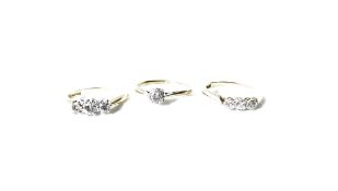 A three stone diamond ring, set with round brilliant cut diamonds, measuring approximately 0.