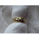 A three stone diamond ring set with three round old cut diamonds,