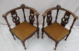 A pair of 19th century continental corner chairs, carved with a figure head and leaves,