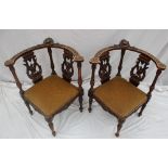 A pair of 19th century continental corner chairs, carved with a figure head and leaves,