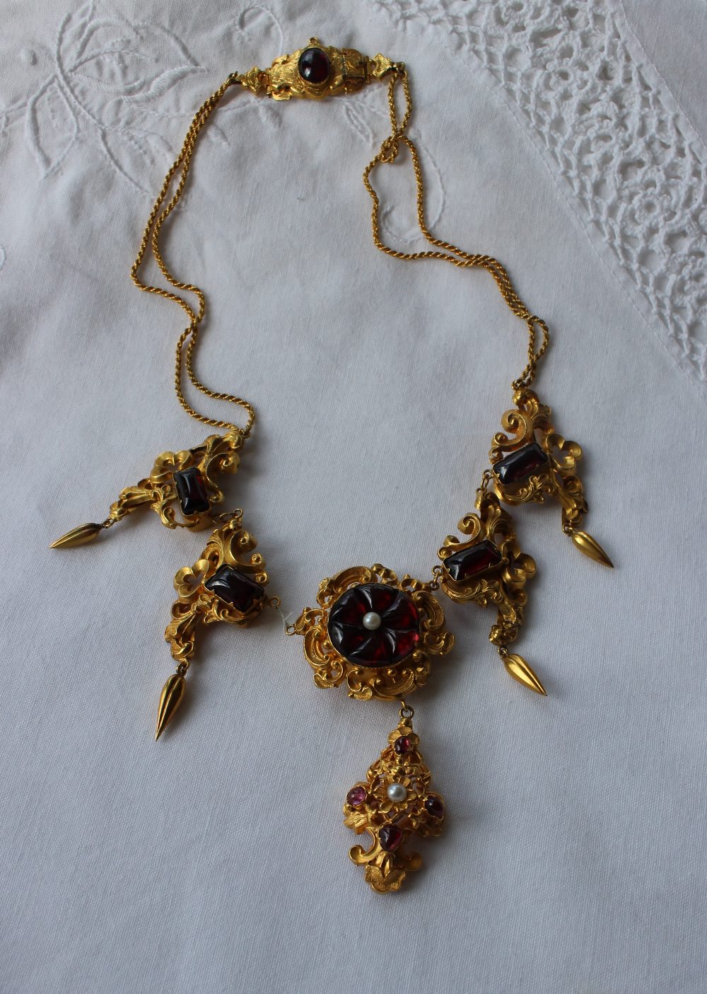 A yellow metal and red stone necklace with scrolling leaf design with pear shaped drops - Bild 3 aus 4