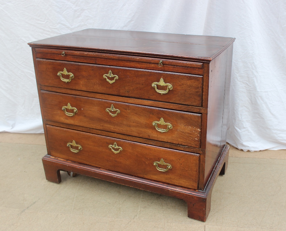 A George III style mahogany chest the rectangular planked top above a brushing slide and three