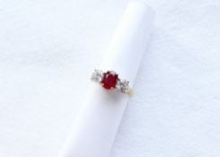 A ruby and diamond ring, the central oval mixed cut strong red transparent natural ruby 7.55mm x 5.
