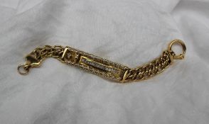 A yellow metal identity bracelet set with a horses head,