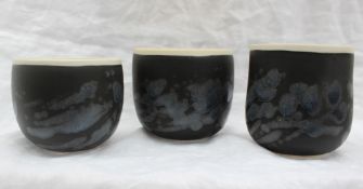Studio pottery by Barbara Ineson - A set of three pottery vases with a black body and abstract