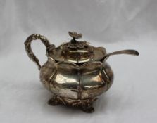 A George IV silver mustard pot and cover the domed cover with a floral finial,