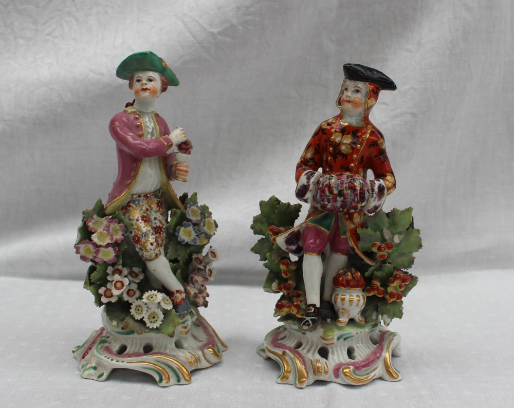 A pair of 18th century porcelain figures, possibly Bow, the one squeezing grapes into a chalice,