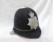 A Metropolitan police helmet together with an enamelled badge