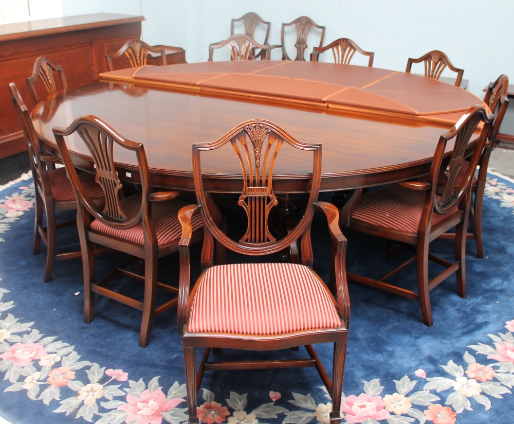 A large circular reproduction mahogany dining table and twelve dining chairs with wheat sheaf