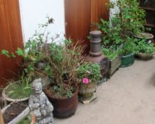 A cast iron chimenea together with a collection of plant pots etc