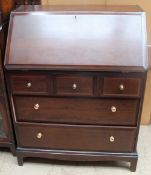 A 20th century stag bureau with a sloping fall and five drawers on bracket feet