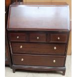 A 20th century stag bureau with a sloping fall and five drawers on bracket feet