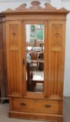 An Edwardian satin walnut wardrobe with a mirrored door