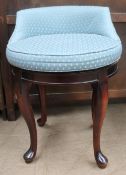 A dressing table stool with a pad upholstered seat